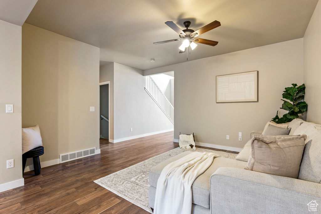 Living room featuring dark wood-style floors and a ceiling fan
