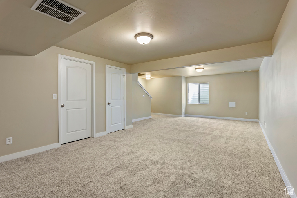 Below grade area with light carpet and baseboards