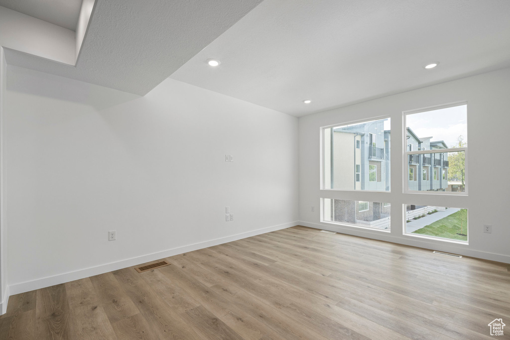 Empty room featuring light wood-style floors and recessed lighting