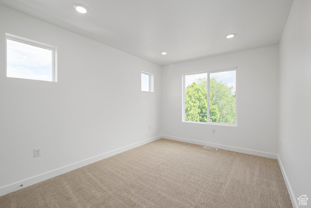 Unfurnished room with recessed lighting and light carpet