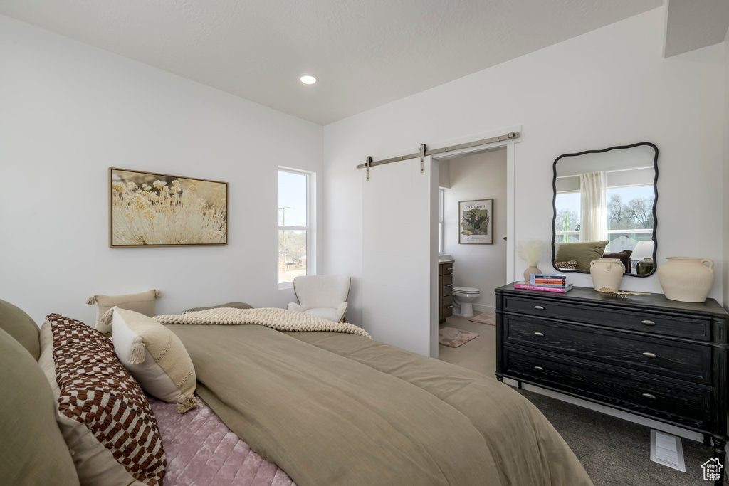 Bedroom featuring a barn door, carpet, ensuite bathroom, and recessed lighting