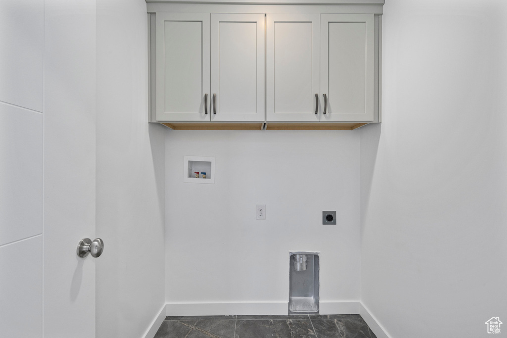 Washroom with washer hookup, electric dryer hookup, and cabinet space