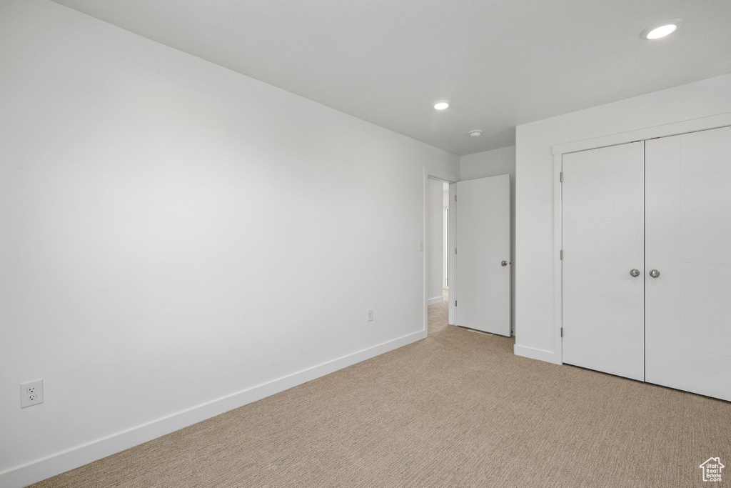 Unfurnished bedroom with carpet floors, recessed lighting, and a closet