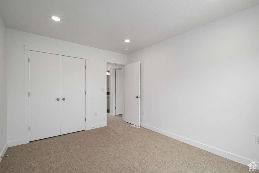 Unfurnished bedroom featuring carpet, recessed lighting, and a closet