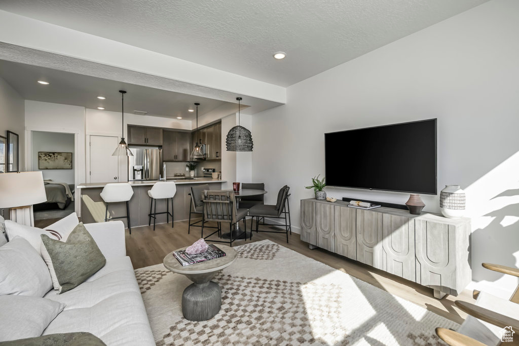 Living area featuring wood finished floors, recessed lighting, and a textured ceiling