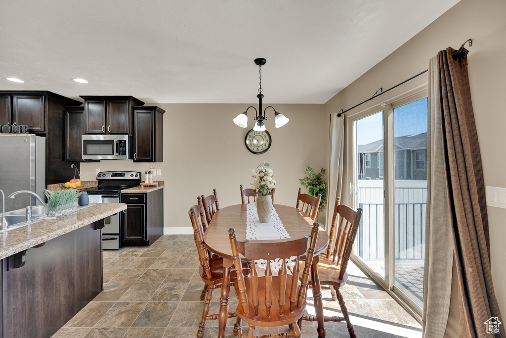 Dining area with recessed lighting, a chandelier, and light stone finish floors