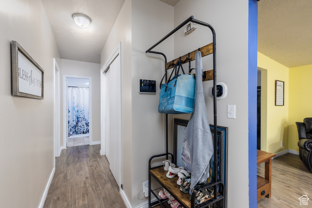 Hallway featuring wood finished floors and baseboards