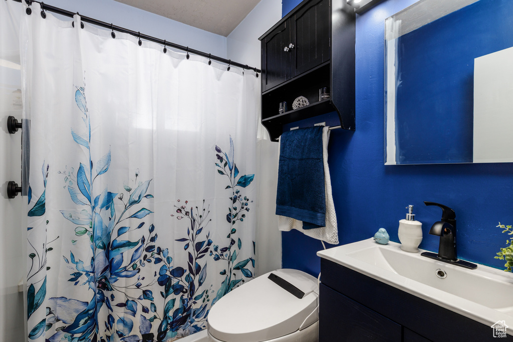 Full bath with vanity and a shower with shower curtain