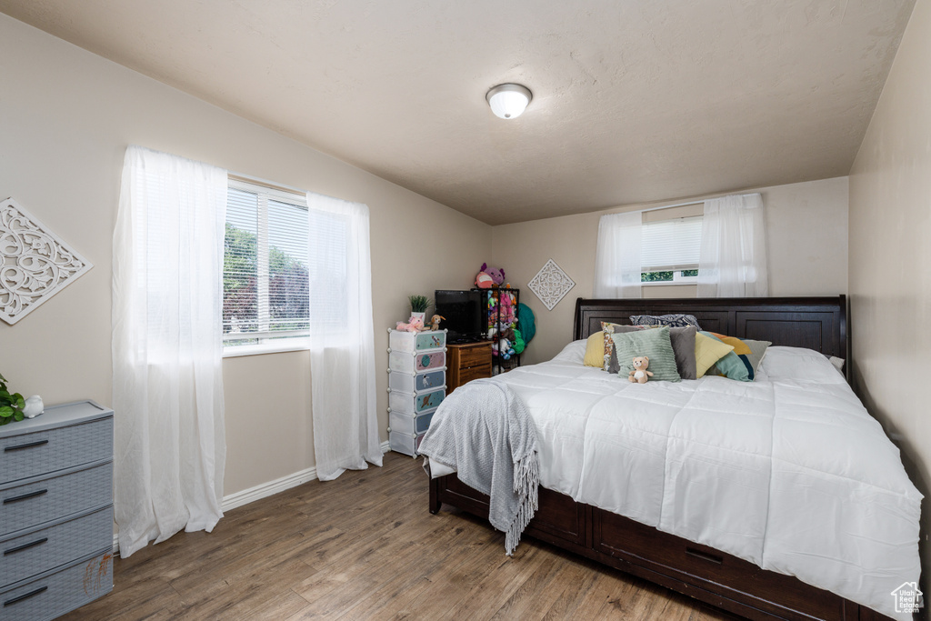 Bedroom with wood finished floors and baseboards