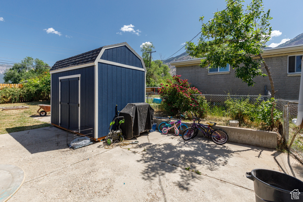 View of patio featuring area for grilling and a storage shed