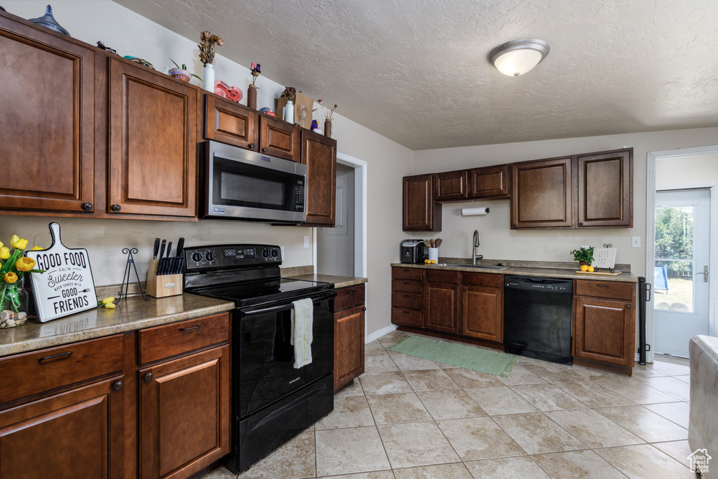 Kitchen featuring black appliances and a textured ceiling