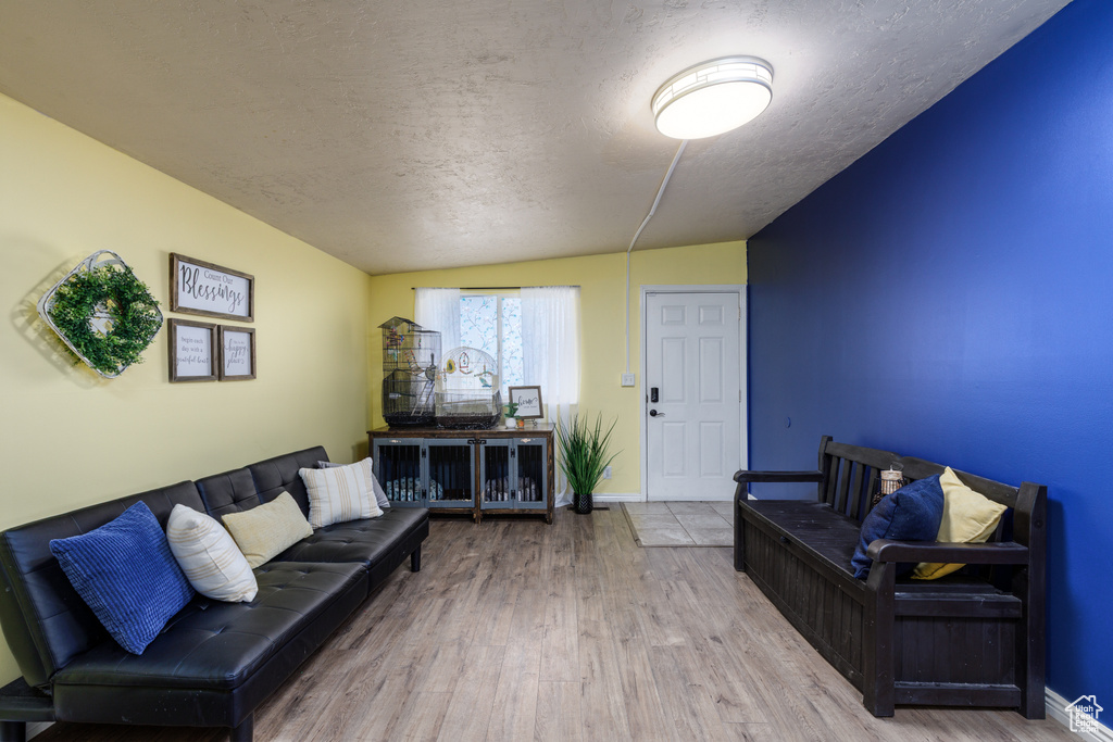 Living room with a textured ceiling and wood finished floors