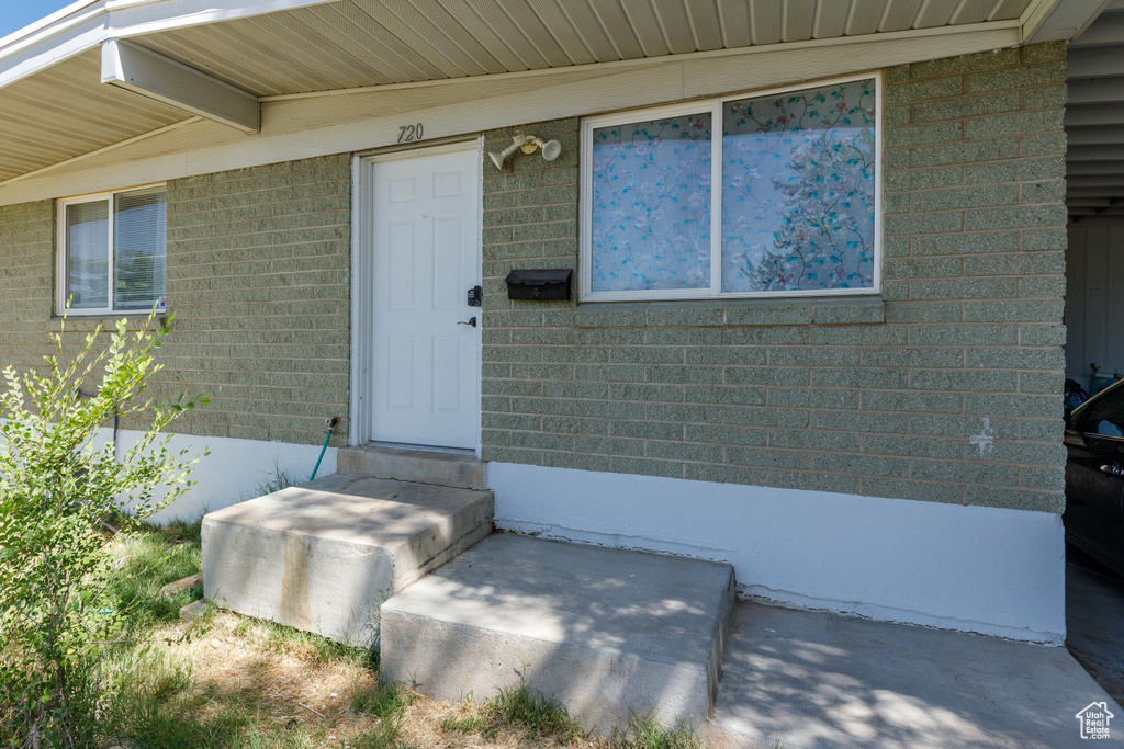 View of exterior entry featuring brick siding