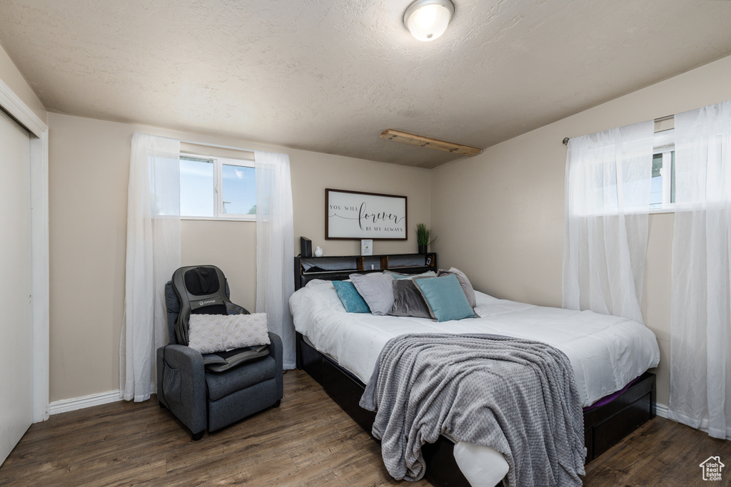 Bedroom with wood finished floors and baseboards