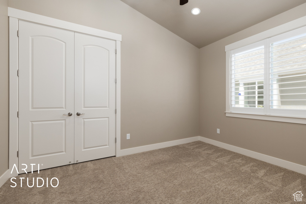 Unfurnished bedroom with vaulted ceiling, carpet flooring, a closet, and recessed lighting