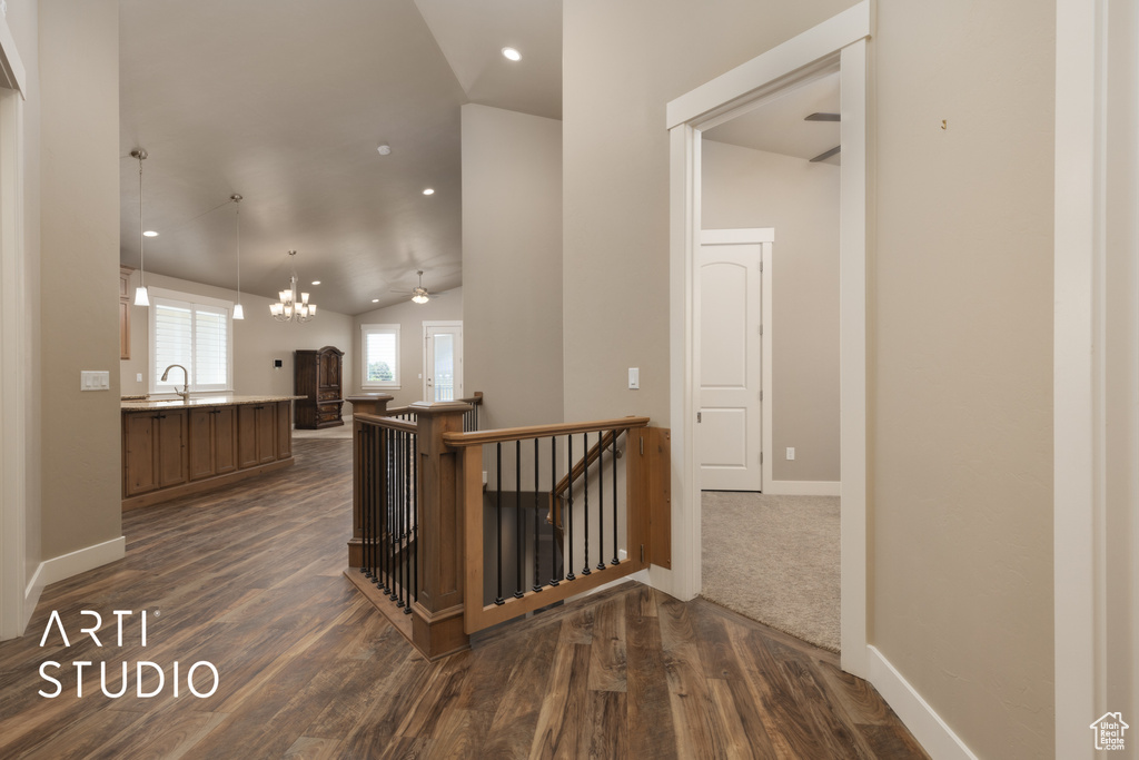 Hall featuring an upstairs landing, lofted ceiling, dark wood-style floors, and recessed lighting