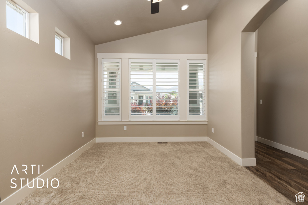 Carpeted spare room featuring recessed lighting, vaulted ceiling, arched walkways, and ceiling fan