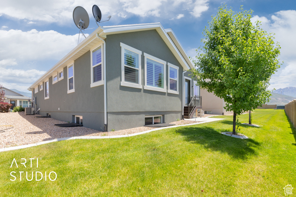 View of side of home with a central air condition unit