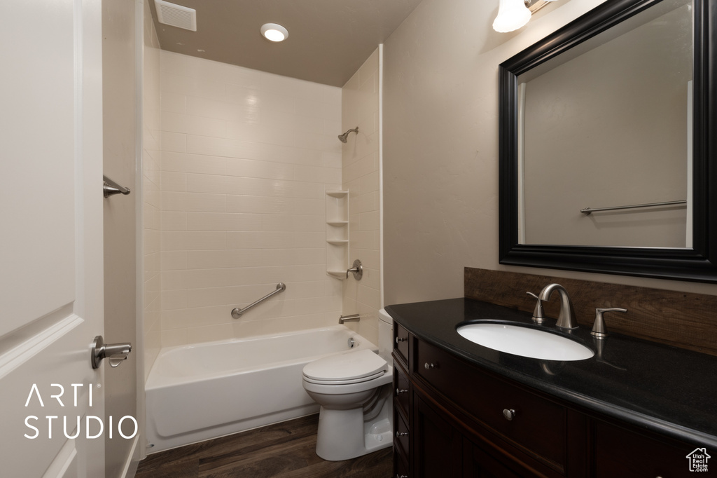 Full bathroom featuring vanity, wood finished floors, shower / bathtub combination, and recessed lighting