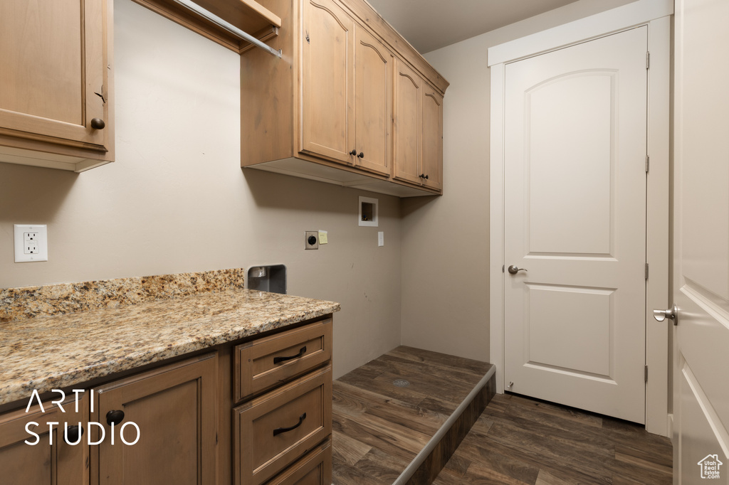 Laundry room with electric dryer hookup, washer hookup, dark wood-type flooring, and cabinet space