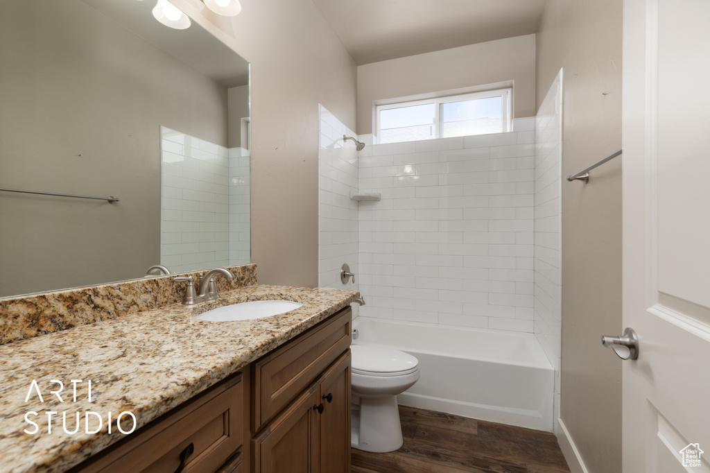 Full bath with vanity, wood finished floors, and shower / bath combination
