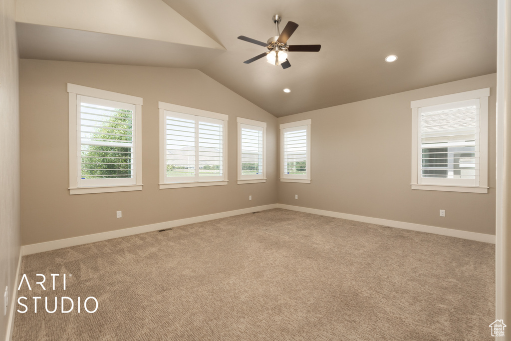 Carpeted spare room featuring vaulted ceiling, ceiling fan, and recessed lighting