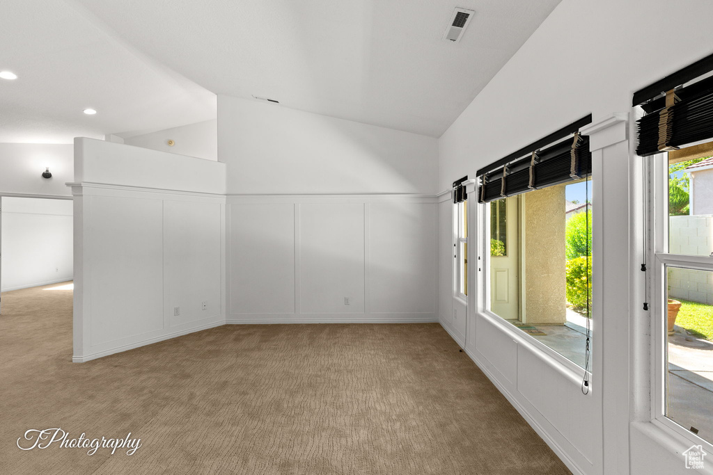 Spare room featuring light carpet, high vaulted ceiling, and recessed lighting