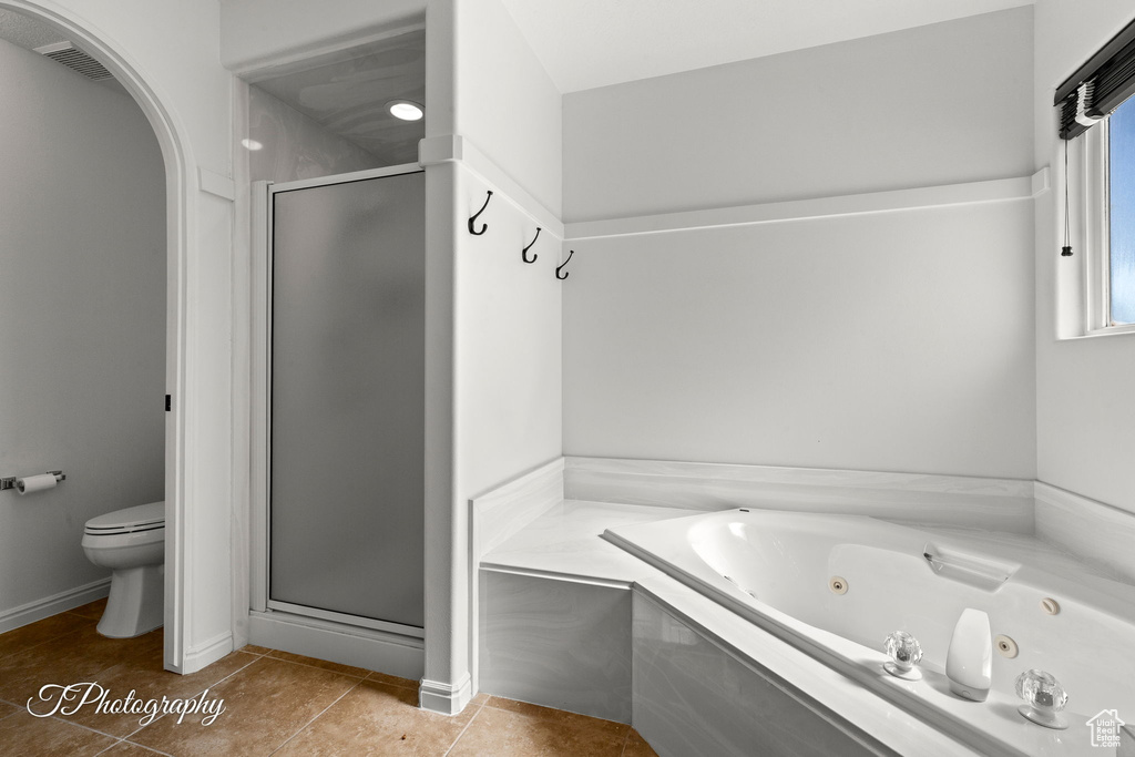 Bathroom with a shower stall, a jetted tub, and tile patterned floors