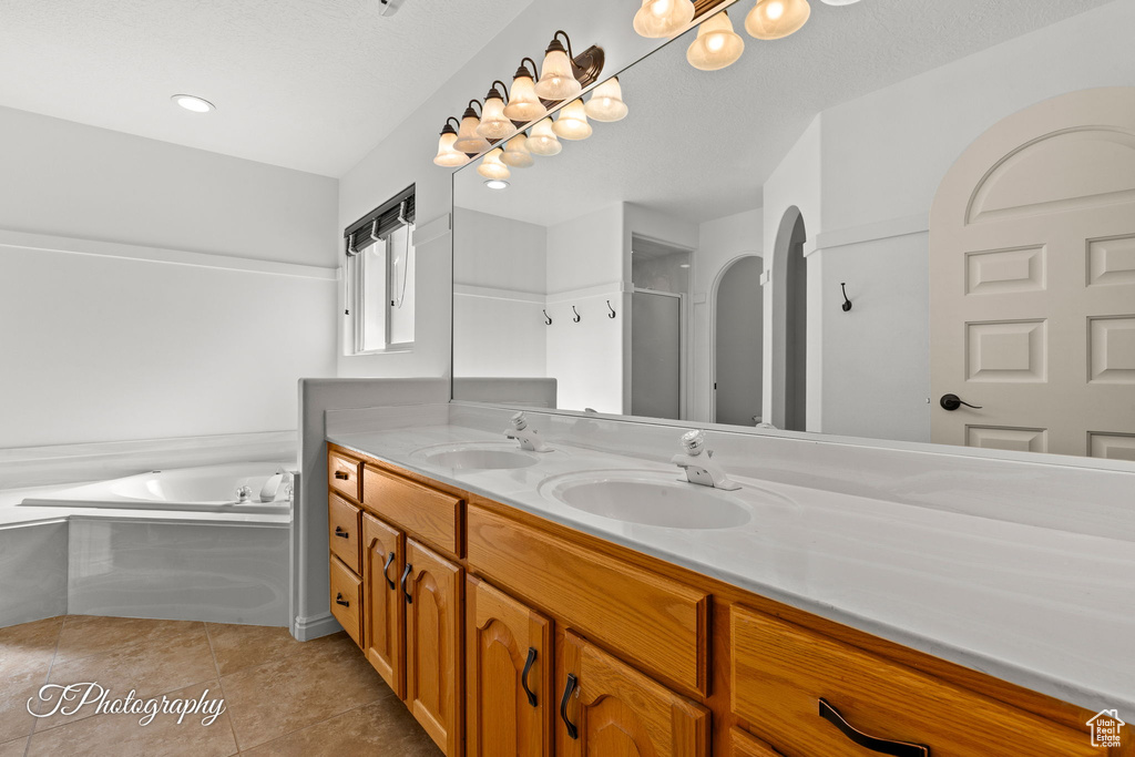 Bathroom featuring double vanity, a bath, tile patterned floors, and a shower