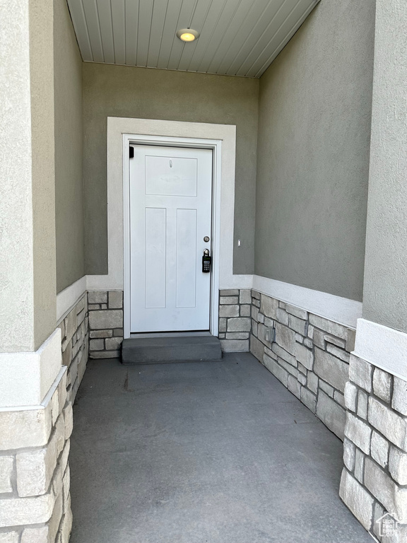 Entrance to property with stucco siding and stone siding