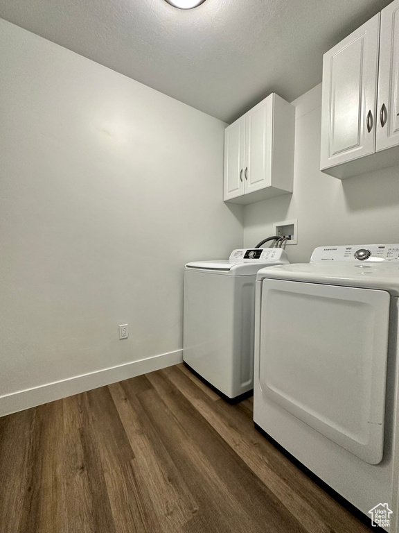 Laundry room with cabinet space, independent washer and dryer, and dark wood-style flooring