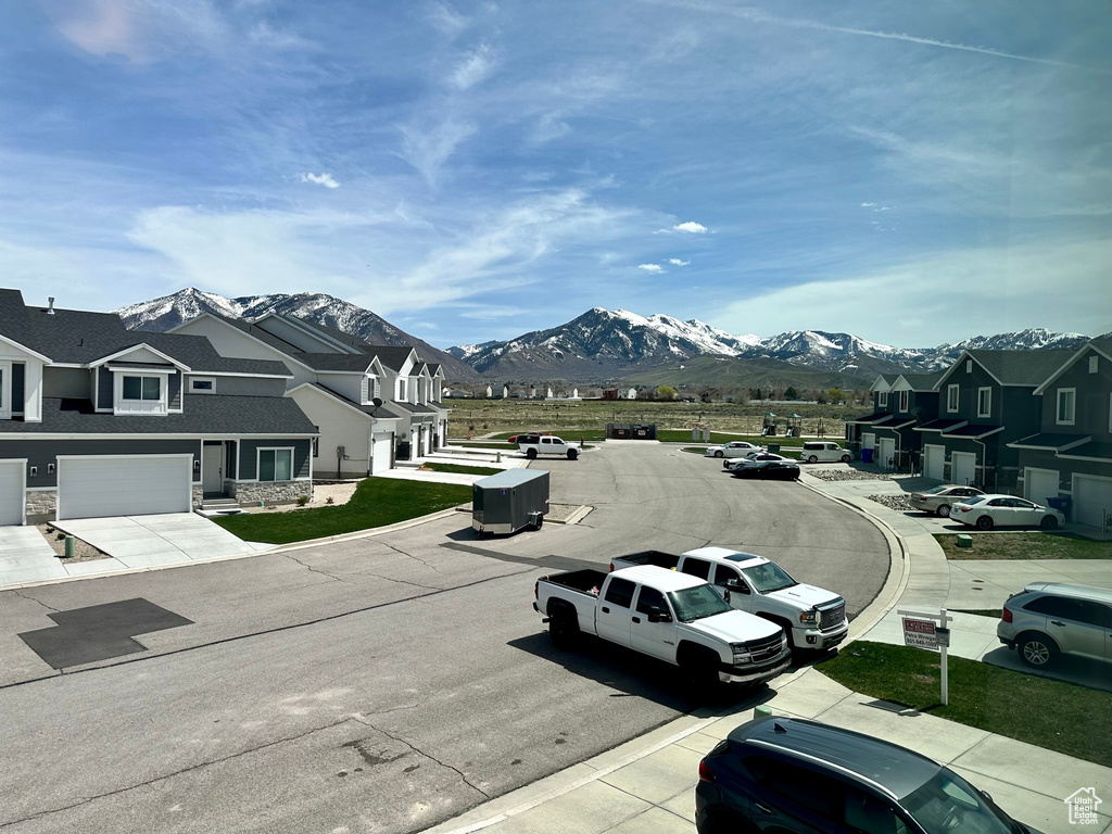 View of asphalt road with a mountain view, curbs, and a residential view