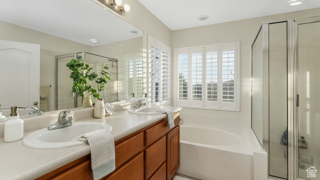 Full bathroom featuring double vanity, a stall shower, and a garden tub