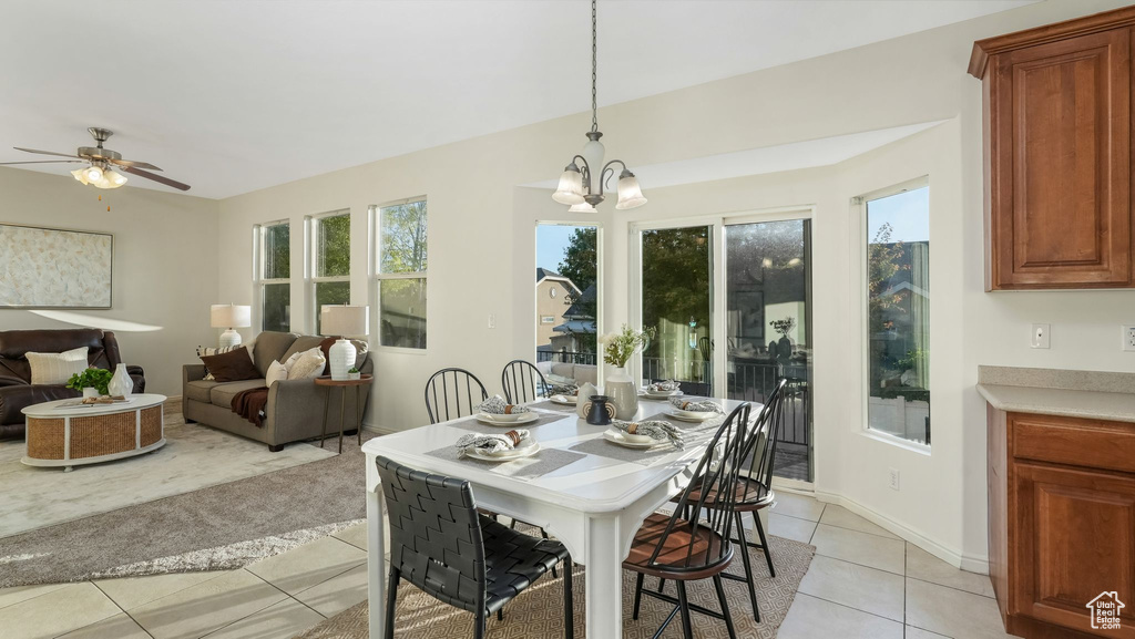 Dining area with light tile patterned floors, ceiling fan, and a chandelier