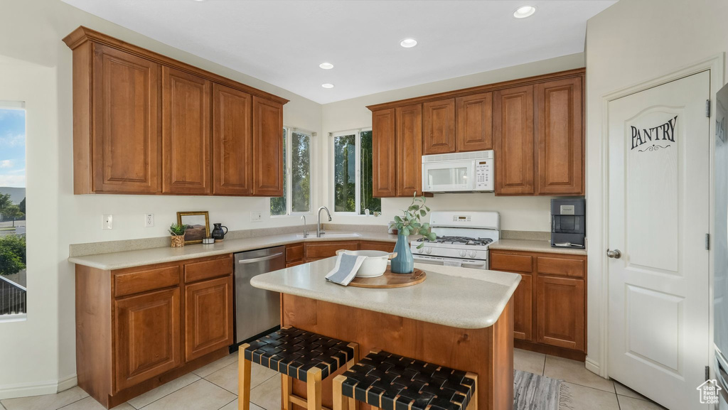 Kitchen with white appliances, light tile patterned floors, light countertops, and recessed lighting