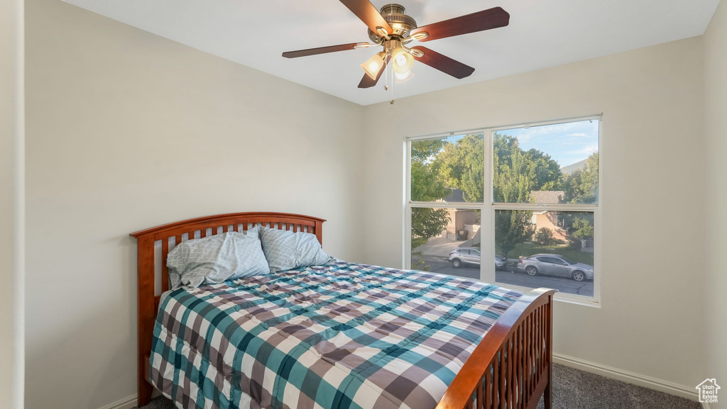 Carpeted bedroom featuring baseboards and ceiling fan