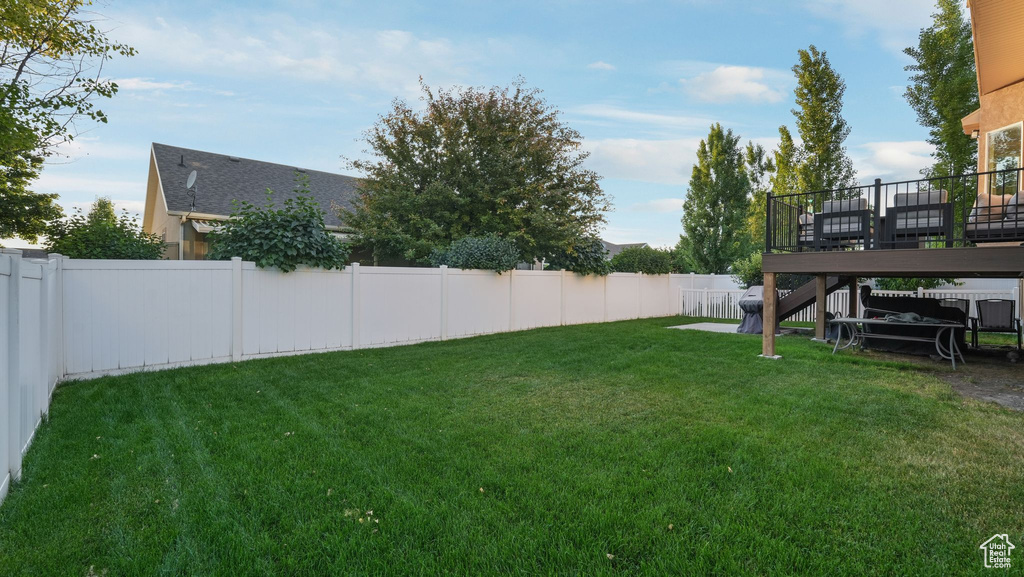 Fenced backyard featuring a deck and stairs