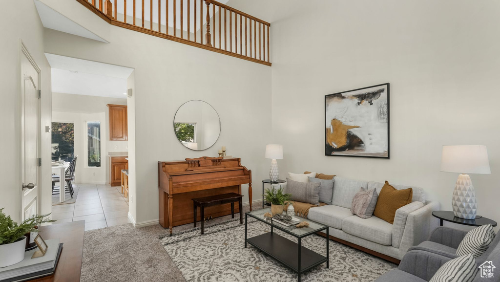 Living room with a high ceiling and light tile patterned flooring