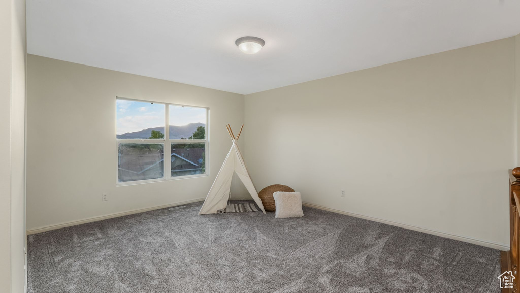 Spare room featuring carpet and baseboards