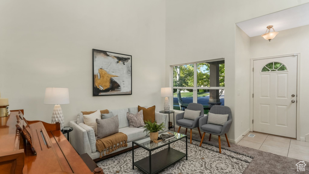 Living room with tile patterned floors and a towering ceiling