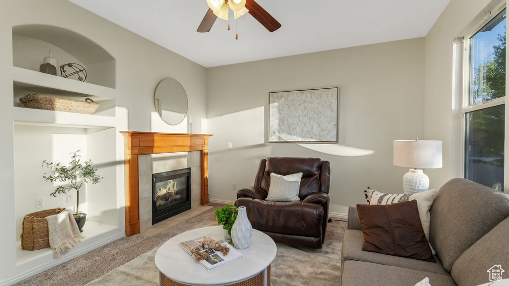 Living room with light carpet, a tiled fireplace, and ceiling fan