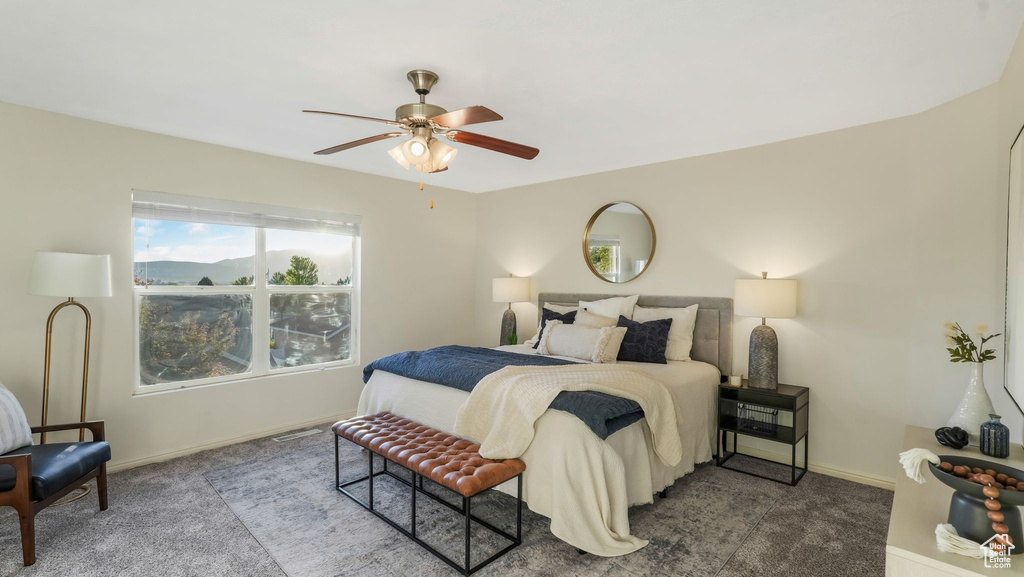 Carpeted bedroom with baseboards and a ceiling fan
