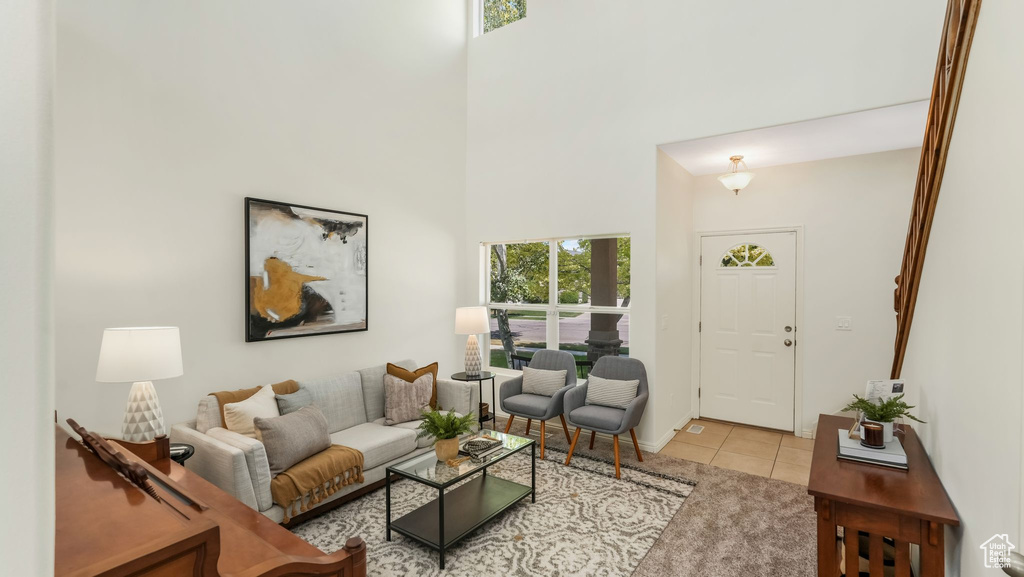 Living area featuring light tile patterned floors and a high ceiling