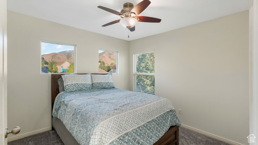Carpeted bedroom featuring baseboards and a ceiling fan