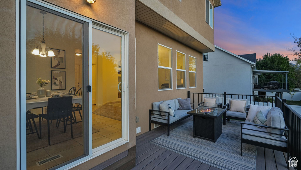 Deck at dusk with an outdoor living space with a fire pit