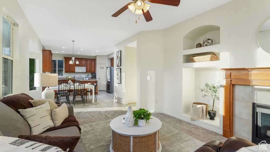 Living room with a tile fireplace, a ceiling fan, and recessed lighting