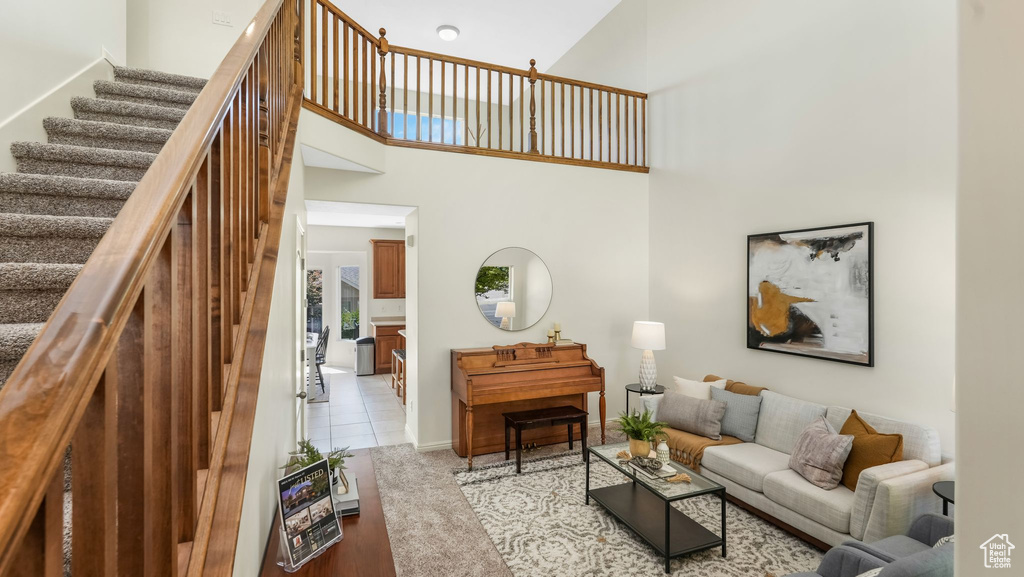 Living area with stairway and a high ceiling