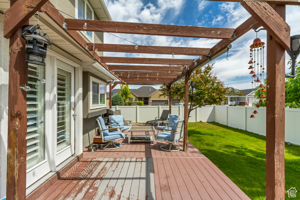Wooden terrace with a fenced backyard, a pergola, and outdoor lounge area