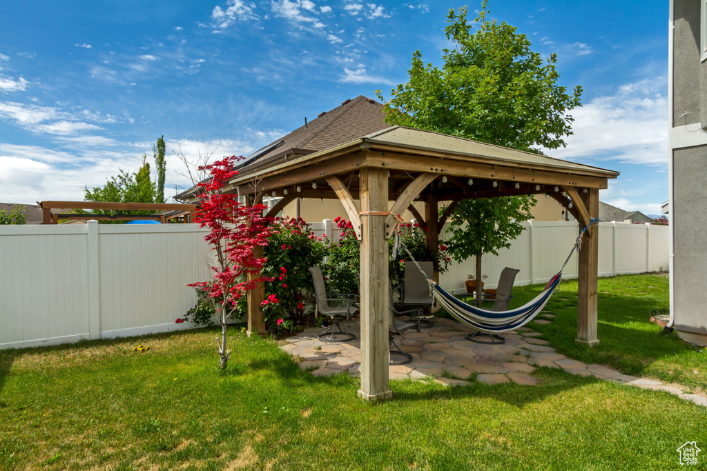 Fenced backyard featuring a gazebo and a patio area