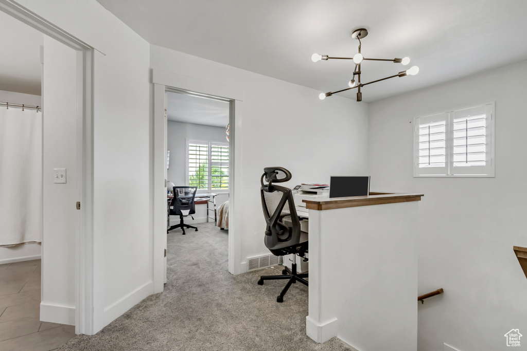 Home office featuring a chandelier and carpet flooring